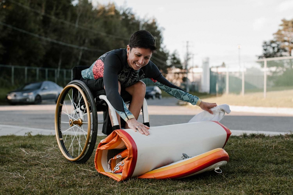 Geneviève Hallé, souriante, qui range son paddleboard.
