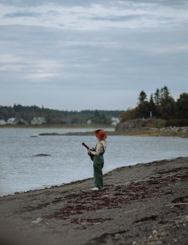 Artist Klô Pelgag with her guitar on the banks of the St. Lawrence, in Rivière-Ouelle, Bas-Saint-Laurent.